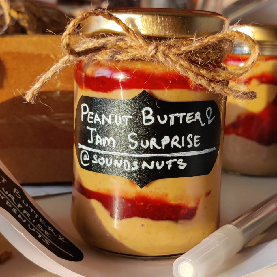 Jar of peanut butter and jam surprise with a label on a table